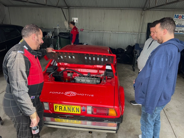 Fiat Abarth driver relaxing in the pits with the door open